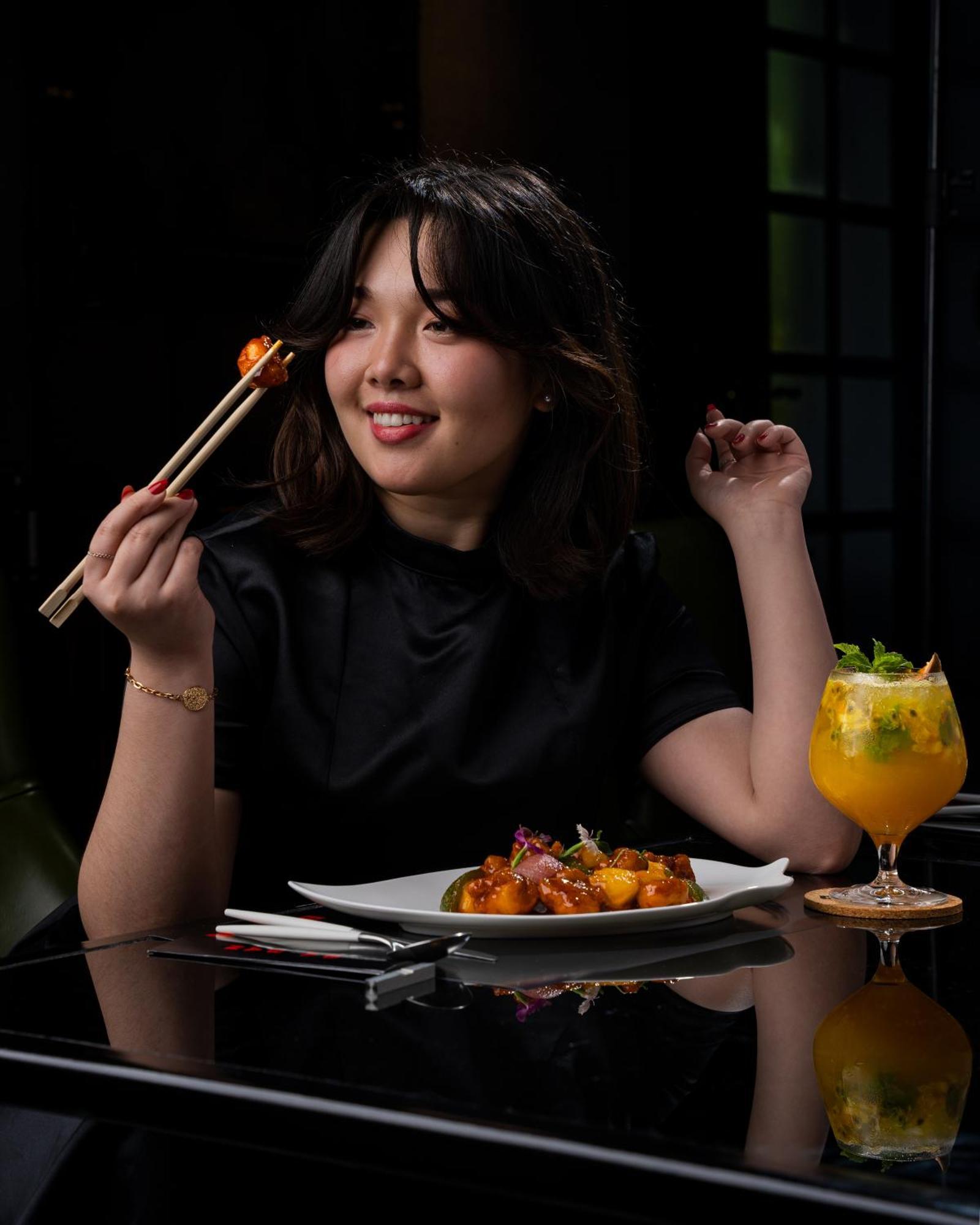 W Muscat Hotel Bagian luar foto A woman eating with chopsticks